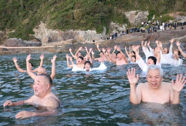 日の出の方角に向け万歳する元旦禊（みそ）ぎの参加者ら