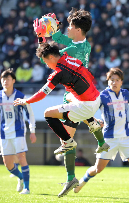 前半、日章学園・高岡（手前）と競り合いボールをキャッチする矢板中央ＧＫ藤間