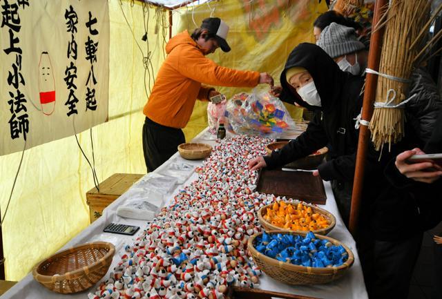 「起き上がり小法師」を買い求める人でにぎわう十日市=2025年1月10日午前10時55分、福島県会津若松市、斎藤徹撮影