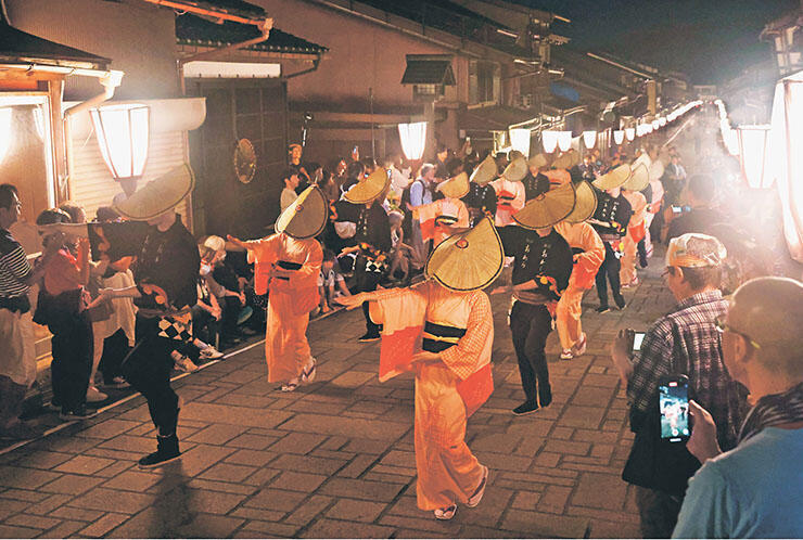 「おわら風の盆」で編みがさをかぶって優雅に舞う女性=2023年9月、富山市