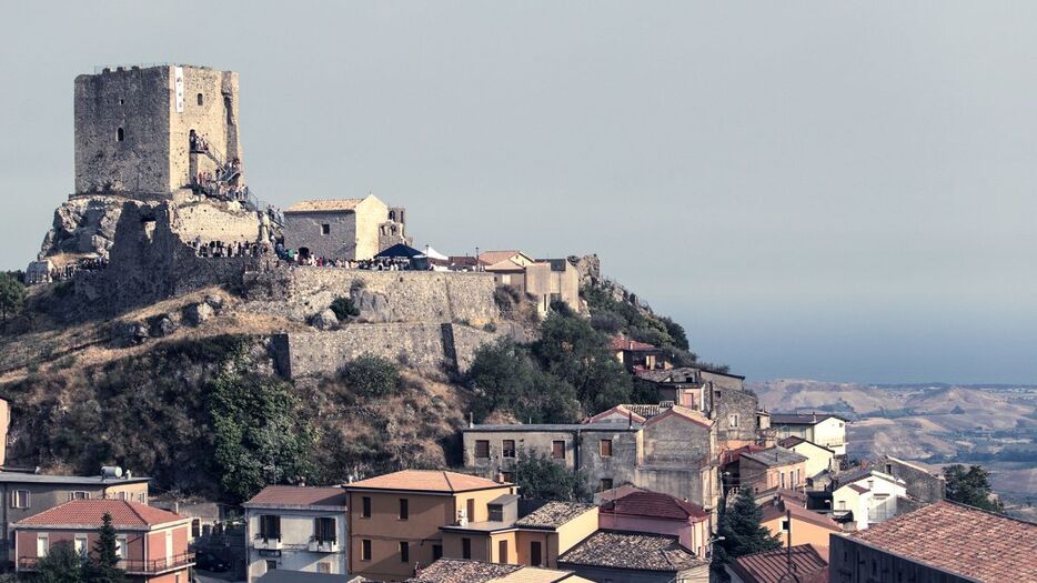 イタリア南部の小さな町、ベルカストロの高台に建つ城と周辺の家々