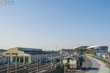 画面左が埼玉高速鉄道の車庫。画面右奥に見えるのが「埼玉スタジアム2002」。車庫の右側に伸びる歩道が浦和美園駅と「埼玉スタジアム2002」を結ぶ歩道で、スタジアムでのイベント開催時には多くの人が通行する（2021年1月、鳴海 侑撮影）。