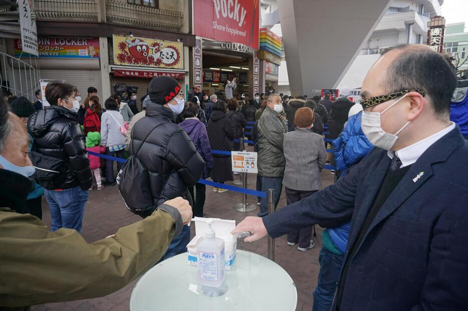 ［写真］豆配りは感染防止策をとりながら行われた