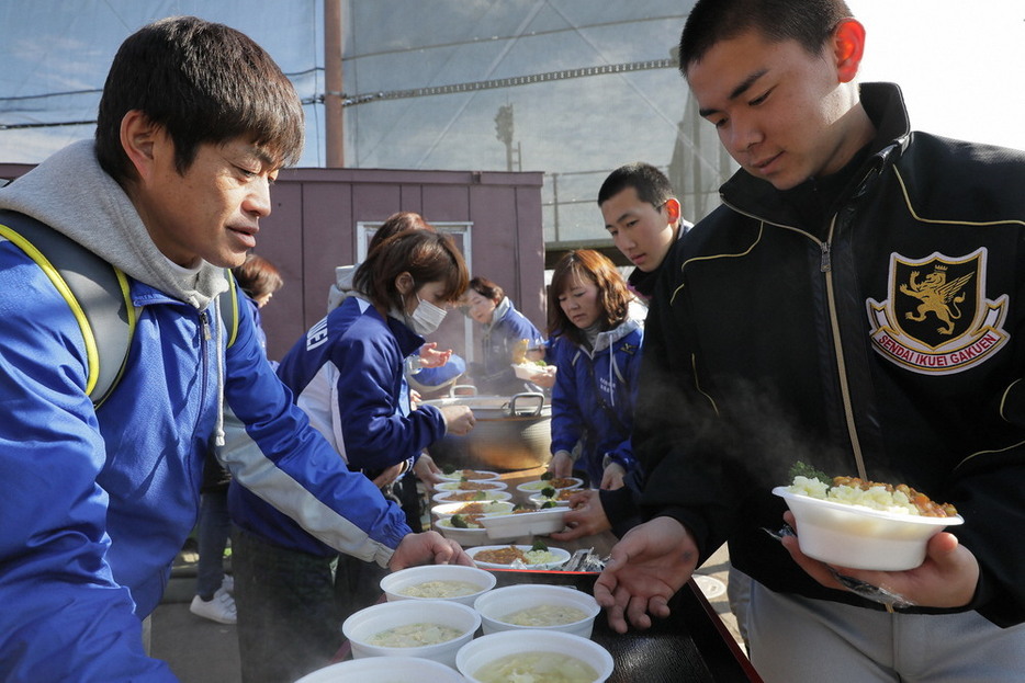 仙台育英ナインに手料理を振る舞う保護者たち（左）＝宮城県多賀城市で２０２０年１月２６日、和田大典撮影