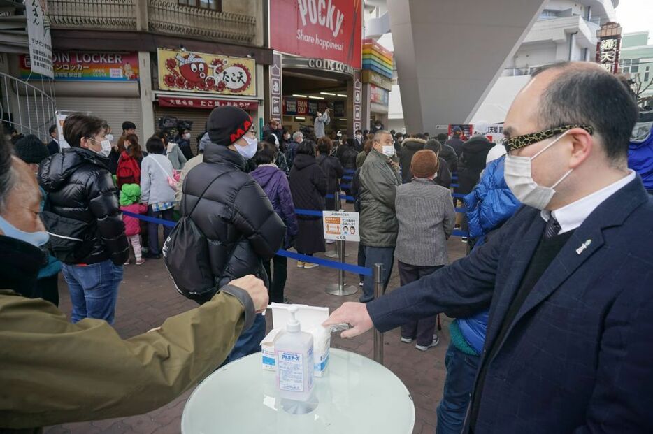 [写真]通天閣で今月1日に行われた豆まきイベントの様子。豆まきをやめ非接触の配布、ソーシャルディスタンスを保つなど感染防止策がしっかりとられていた