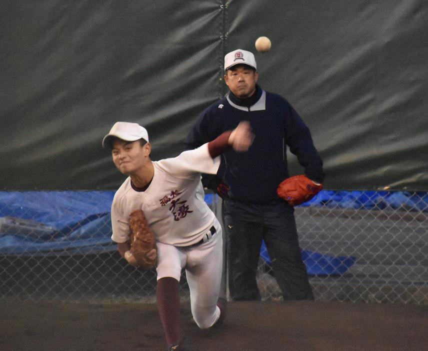 投球練習に励む毛利選手（手前）と見守る八木啓伸監督