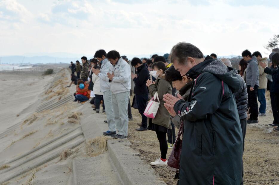 黙祷する被災者ら（宮城県仙台市　写真：Natsuki Sakai／アフロ）