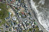 海岸に打ち寄せる波と画面に入れて稲村ヶ崎駅を真上から撮影した。1000形＋20形の鎌倉行きが交換待ちをしているところに、300形＋1000形の藤沢行きが進入する（2013年4月8日、吉永陽一撮影）。