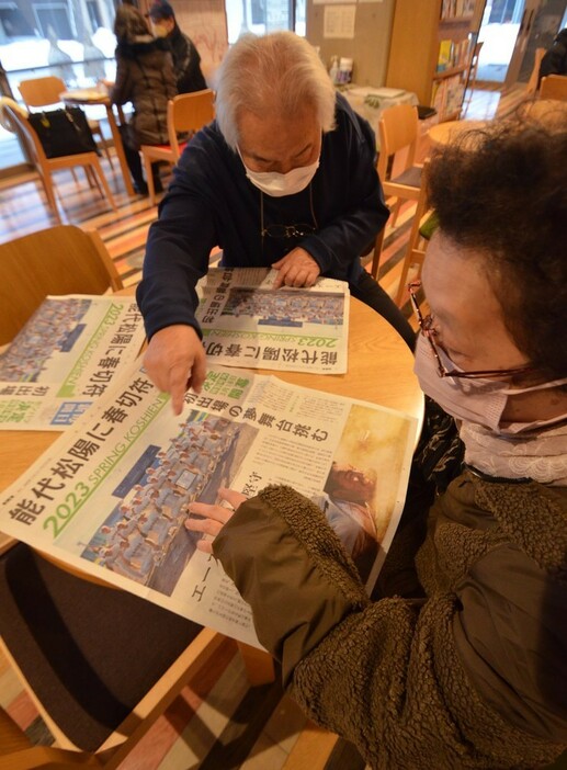 テーブルに号外を広げて喜ぶ人たち＝秋田県能代市役所で２０２３年１月２７日、田村彦志撮影