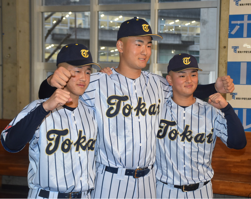 センバツ出場が決まり、肩を組んで写真撮影に応じる、左から北島蒼大、日当直喜、渡部奏楽主将＝あきる野市の東海大菅生高校で