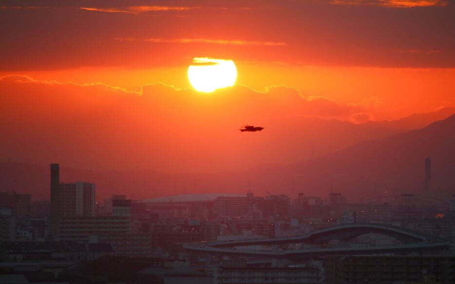 ［写真］雲の隙間から丸く見える2023年の初日の出。写真下の橋は千本松大橋＝1日午前7時20分ごろ、大阪市大正区で