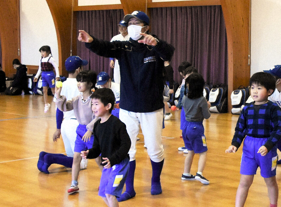 地元のこども園で開かれた野球教室で、子供たちとキャッチボールする野球部員に指示を送る倉吉総合産の定常弘顕監督＝鳥取県で2021年12月23日午後1時49分、野原寛史撮影