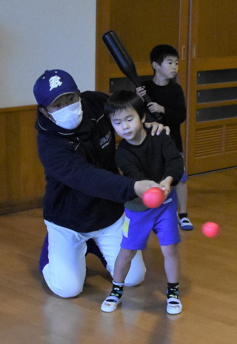 地元のこども園で開かれた野球教室で子供たちにバッティングを体験してもらう倉吉総合産の定常弘顕監督＝鳥取県で2021年12月23日、野原寛史撮影