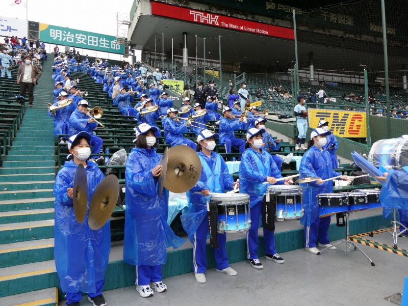 レインコート姿で懸命に演奏する近江応援団＝阪神甲子園球場で2022年3月31日、岸本悠撮影