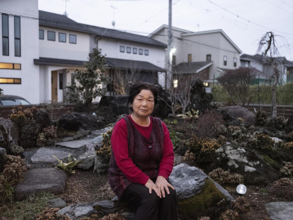 半谷八重子さん（75）。宇都宮市に新たに建てた自宅前で