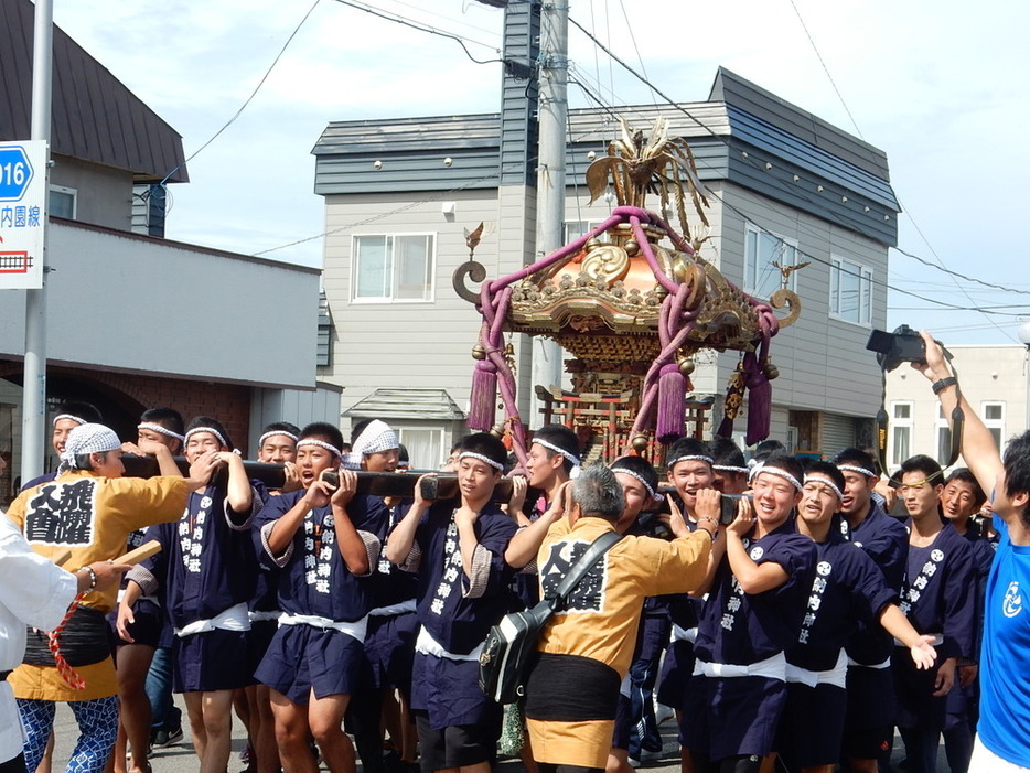 ２０１９年９月にあった納内神社例大祭で、地元のみこしを担ぐ野球部員ら＝クラーク記念国際野球部後援会提供