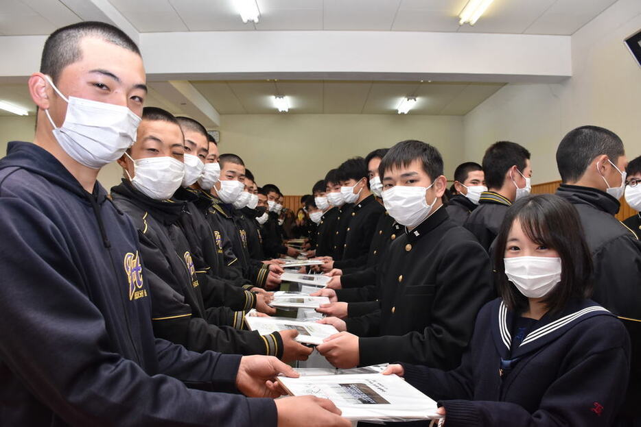 野球部の在校生（左側）から色紙を手渡される卒業生ら＝兵庫県稲美町中一色の東播磨高校で、後藤奈緒撮影