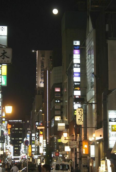 [写真]北新地からも月がよくみえ、即席の観月会をする店主もいた＝8日午後7時半ごろ、大阪市北区で