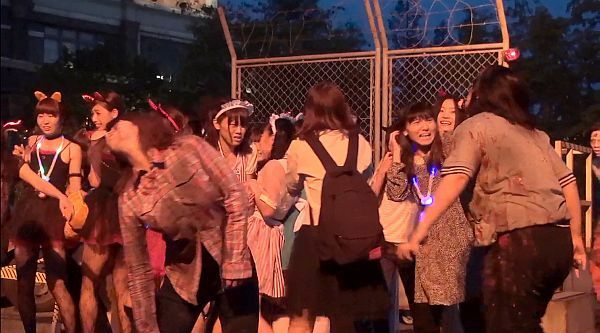 [写真]ゾンビに襲われ悲鳴をあげる仮装したゲストたち＝11日午後6時半ごろ、大阪市此花区で