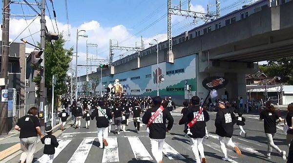 [写真]やりまわし後のだんじりを追いかけたが、そう簡単には追いつかない。右上は南海電車＝7日午後2時ごろ、大阪府岸和田市で