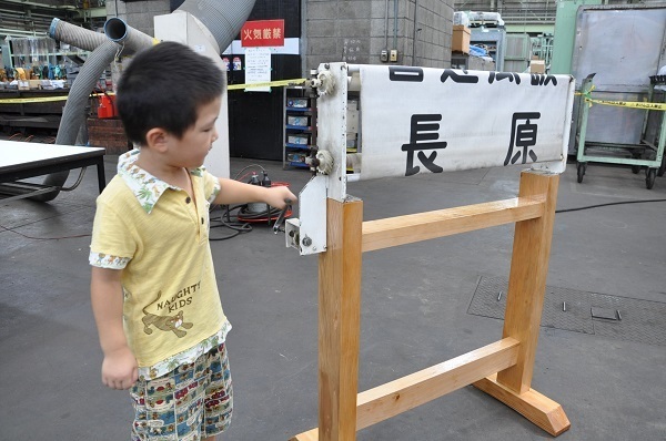 [写真]子どもがハンドルをぐるぐる回す方向幕の操作体験＝大阪市城東区で