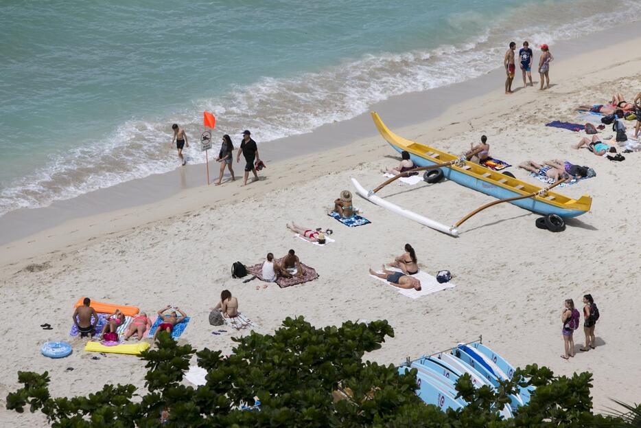 砂浜にとどまる人々＝2015年8月25日（写真：ロイター/アフロ）