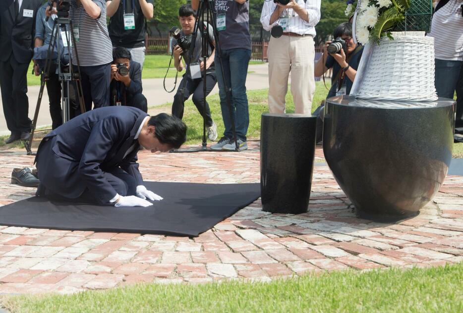 独立運動家らを追悼する記念碑の前にひざまずく鳩山由紀夫元首相＝2015年8月12日（写真：Lee Jae-Won/アフロ）