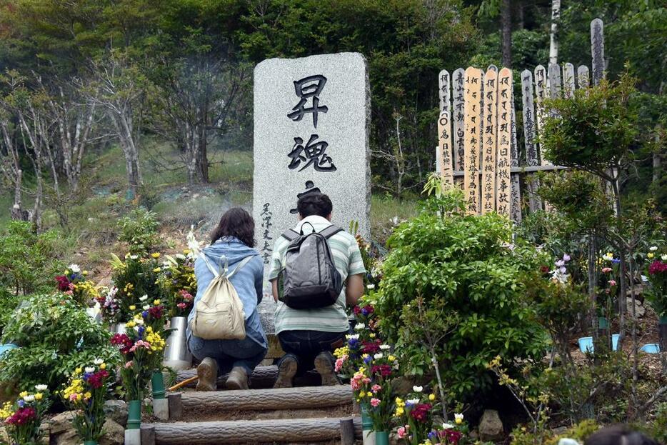 [写真]日航機墜落事故から30年。現場の御巣鷹の尾根に建てられた「昇魂之碑」には慰霊登山した人たちが犠牲者の冥福を祈った（Natsuki Sakai/アフロ）