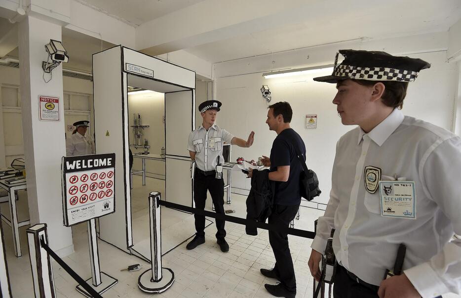 入り口で客をチェックするパフォーマー＝2015年8月20日（写真：ロイター/アフロ）