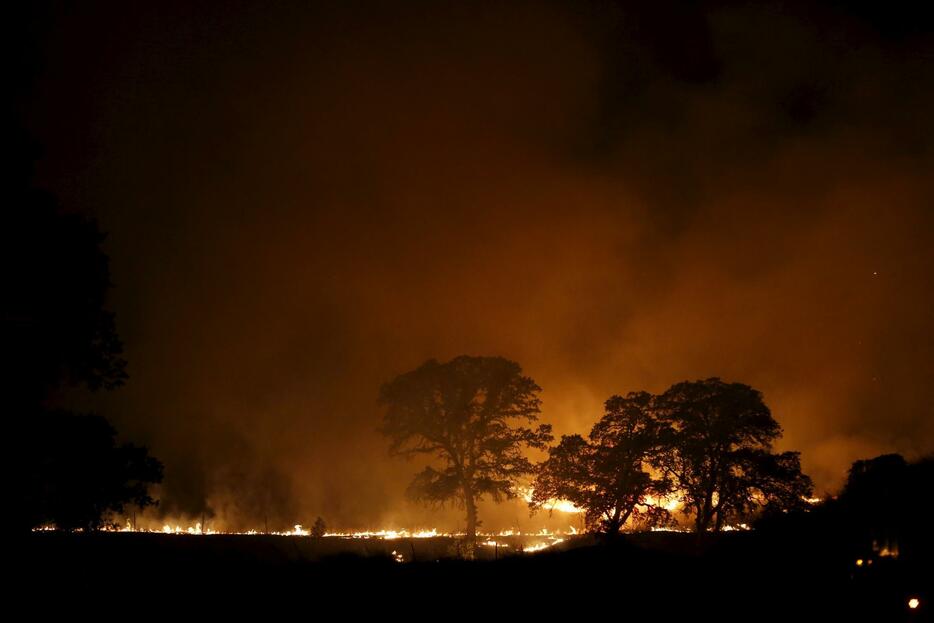 カリフォルニア州のクリアレイク付近で夜も燃え続ける炎＝2015年8月3日（写真：ロイター/アフロ）