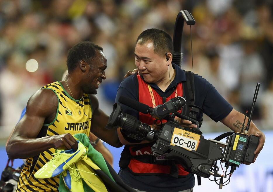 カメラマンと会話するボルト。まだ男子400mリレーが残っている＝2015年8月27日（写真：ロイター/アフロ）