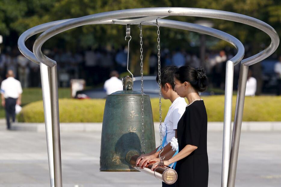 「平和の鐘」を打ち鳴らす遺族代表ら＝2015年8月6日（写真：ロイター/アフロ）