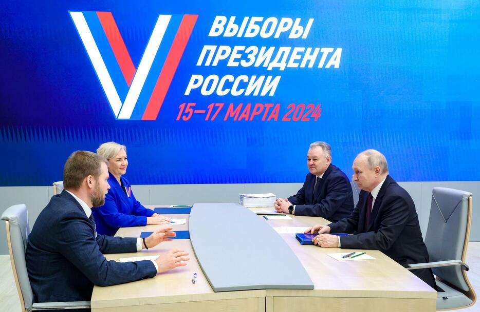 モスクワの中央選挙管理委員会を訪れ、来年3月の大統領選立候補に必要な書類を提出したロシアのプーチン大統領（右）＝18日（タス＝共同）