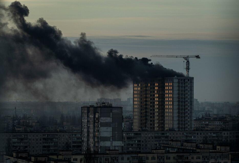 29日、ウクライナの首都キーウで、ロシア軍による攻撃を受け黒煙が上がる建物（ロイター＝共同）