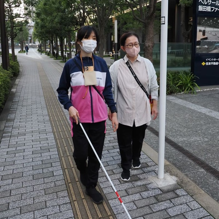 アイナビのお知らせを聞き、標識ポールの脇を慎重に抜ける宮崎さん＝１０月１２日