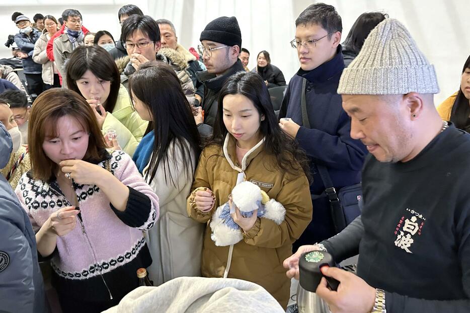 イベント会場で焼酎のお湯割りを飲む来場者ら＝16日、中国上海市（共同）