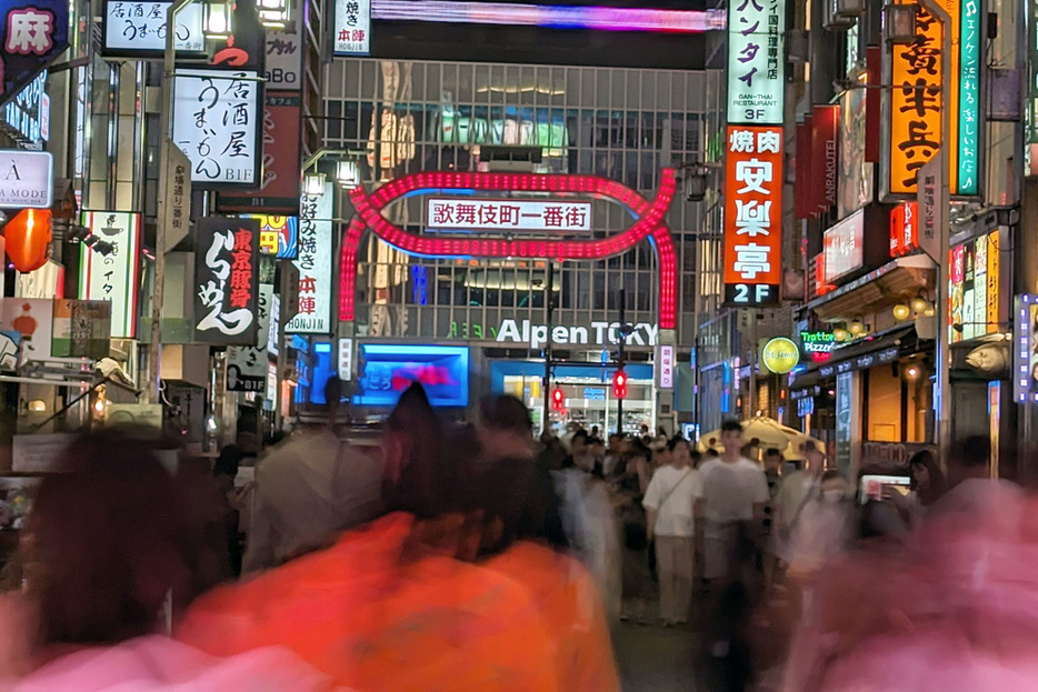 夜のネオンの中、多くの人が行き交う東京・歌舞伎町＝7月下旬