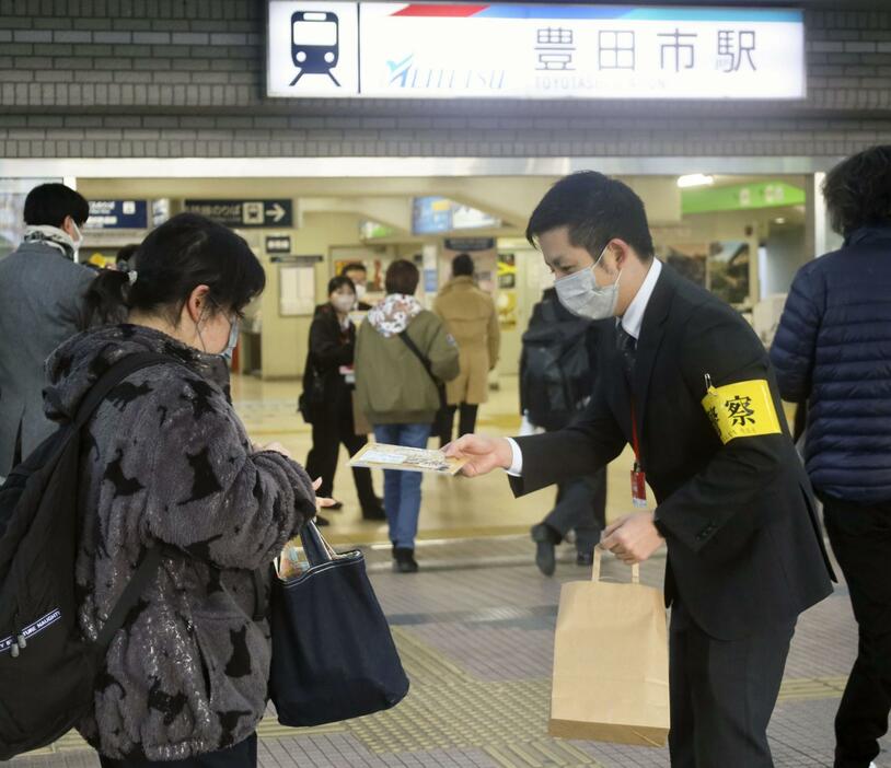 愛知県豊田市で女子高生強盗殺人事件の情報提供を求めてチラシを配布する警察官（右）＝8日午前