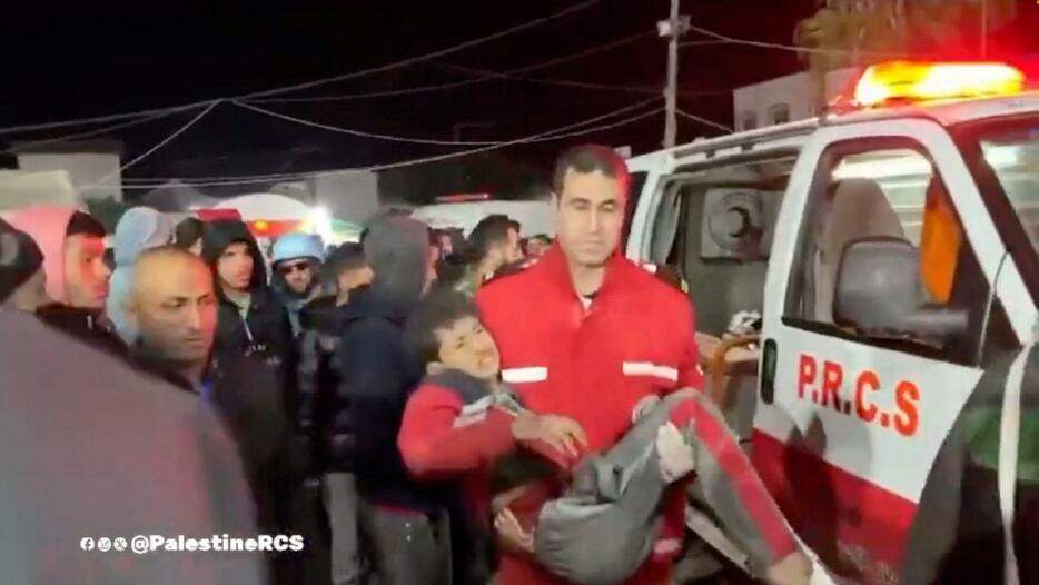 12月30日にパレスチナ赤新月社が公開した映像に写る負傷者を運ぶ担当者＝パレスチナ自治区ガザ中部デールバラハ（赤新月社提供・ロイター＝共同）