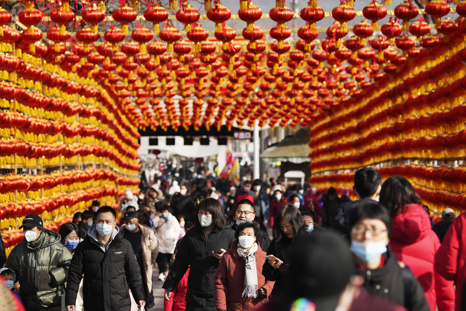 春節を迎え、ちょうちんが飾られた道を歩く人たち＝1月、北京