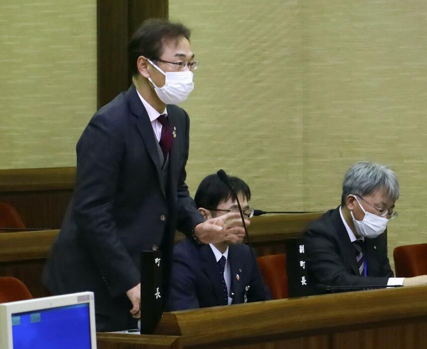 愛知県東郷町議会の本会議で答弁する井俣憲治町長（左）＝21日午後