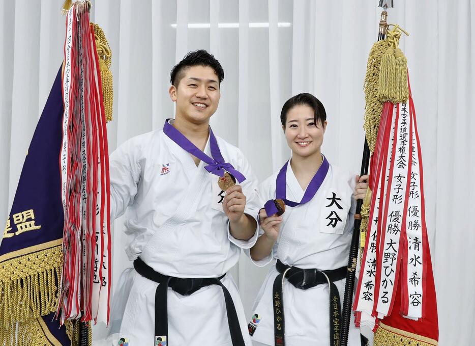 全日本選手権で優勝し、笑顔で撮影に応じる男子形の西山走（左）と女子形の大野ひかる＝日本武道館