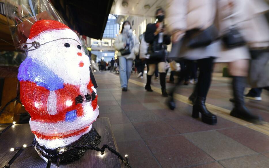 クリスマスの飾りに彩られた街を歩く人たち＝24日、福岡市