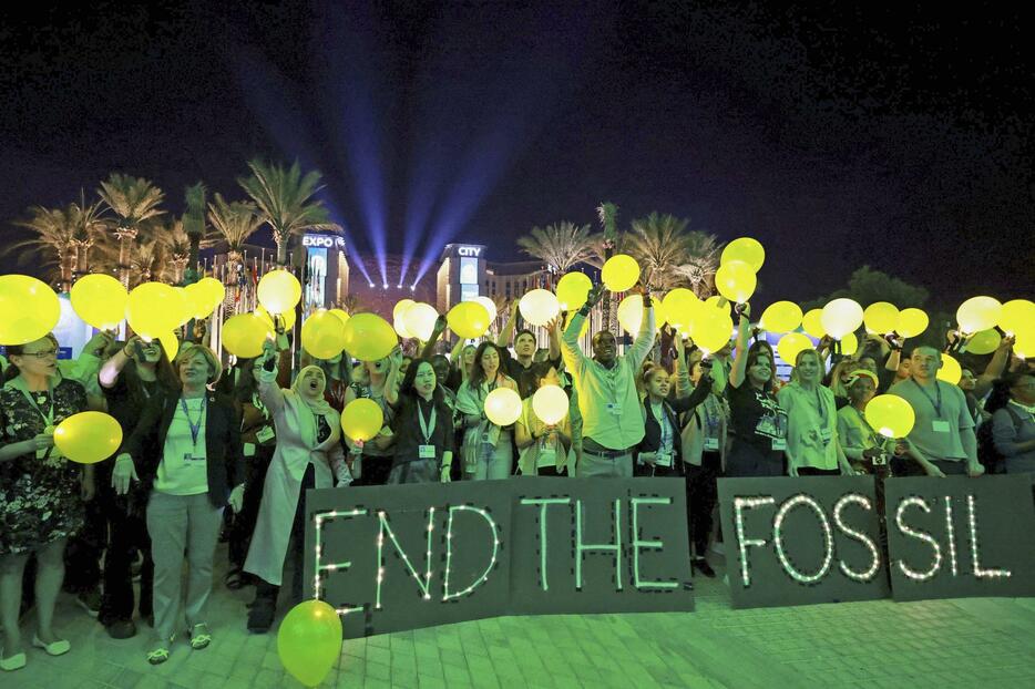COP28の会場で、化石燃料の廃止に合意するよう求める環境団体メンバーら＝11日、アラブ首長国連邦のドバイ（ロイター＝共同）
