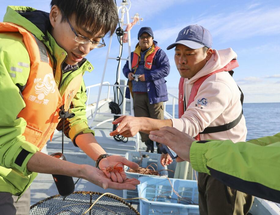 海遊館とオンラインで中継し、収集した深海生物について説明する漁師の松尾拓哉さん（右）＝23日午後、高知県室戸市沿岸