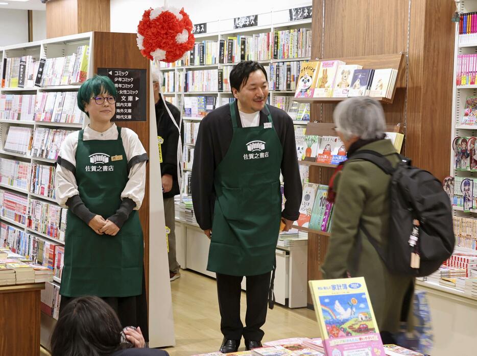 JR佐賀駅構内にオープンした「佐賀之書店」で、訪れた人にあいさつする今村翔吾さん（中央）＝3日午前