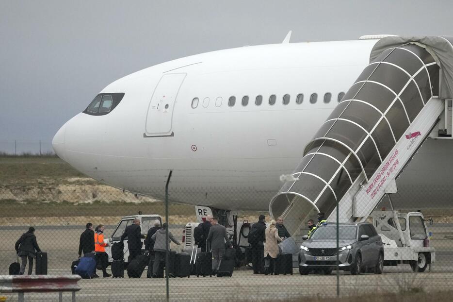 25日、フランス北東部マルヌ県のバトリ空港で離陸を阻止されていた航空機に乗り込む搭乗員ら（AP＝共同）