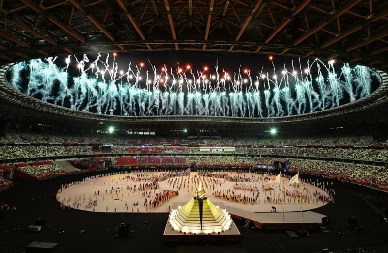 東京五輪の開会式で打ち上げられる花火。手前は点火された聖火台＝２０２１年７月、国立競技場