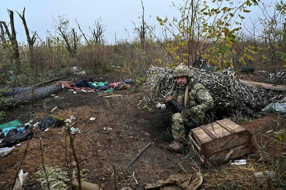 11月4日、ウクライナ南部ザポロジエ州ロボティネ近郊で、ロシア軍がいた場所を調べるウクライナ兵（ロイター＝共同）