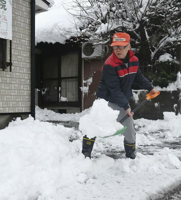 富山市の住宅地で雪かきする人＝23日午前